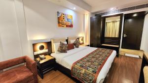 新德里新德里火车站普莱姆巴拉吉豪华酒店的酒店客房设有一张大床和一张沙发。