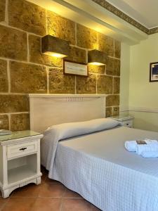 圣维托罗卡波Krimar Hotel的一间卧室设有两张床和石墙