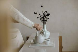釜山Onyouji Stay的把茶倒在桌子上的花瓶里的人