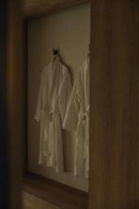 釜山Onyouji Stay的墙上挂着两件白色长袍