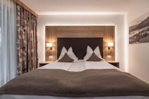普雷瑟格尔塞阿尔盆亚德里亚酒店 的一间卧室配有一张带枕头的大床