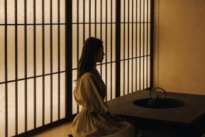釜山Onyouji Stay的坐在窗前的女人的雕像