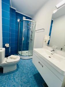 北马马亚-讷沃达里Friday Hotel的带淋浴、卫生间和盥洗盆的浴室