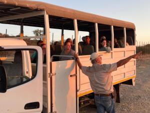 奥奇瓦龙戈Aloegrove Safari Lodge的站在一辆满载人们的公共汽车旁边的人