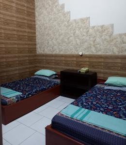 婆罗浮屠ADA Homestay的一间设有两张床的房间,内配电话