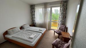 希欧福克Aranypart Hostel的一间卧室设有一张床、一个窗口和一把椅子