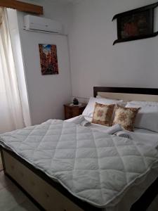 吉诺卡斯特Olivia Guesthouse的卧室配有带枕头的大型白色床