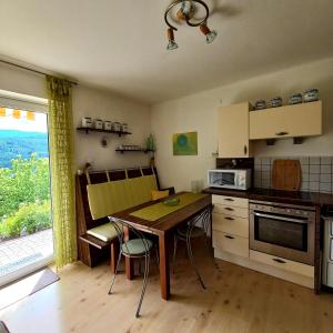 米尔施塔特Ferienwohnung Energie Oase的带桌椅的厨房和带窗户的厨房