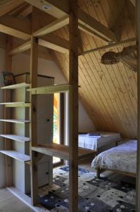 拉伊恰Cataleya Rajcza的一间设有高架床的房间和一张位于房间的床