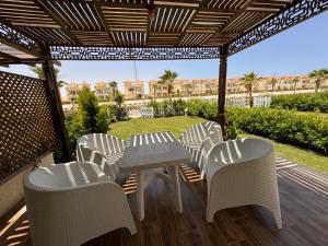 阿莱曼فيلا مميزه جدا في الساحل الشمالي ستيلا هايتس Stella Heights - Sidi Abd El-Rahman villa type M的露台凉棚下的桌椅