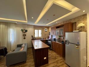 阿莱曼فيلا مميزه جدا في الساحل الشمالي ستيلا هايتس Stella Heights - Sidi Abd El-Rahman villa type M的带沙发和冰箱的厨房