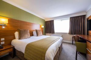 桑德兰Clarion Hotel Newcastle South的酒店客房设有一张大床和一张书桌。