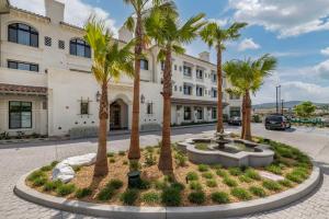 卡拉巴萨斯Cambria Hotel Calabasas - Malibu的一座楼前种有棕榈树的庭院