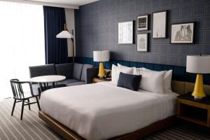 萨默维尔Cambria Hotel Boston Somerville的酒店客房设有一张大床和一张桌子。
