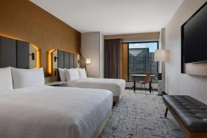 路易斯威尔Tempo By Hilton Louisville Downtown Nulu的酒店客房设有两张床和一台平面电视。