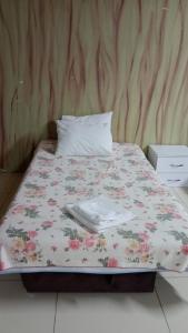 特拉布宗ÇARŞI HOTEL&CAFE的一张带花卉棉被和枕头的床