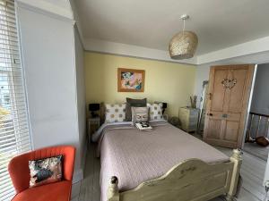 圣艾夫斯Seaforth St Ives的一间卧室配有一张床和一张橙色椅子