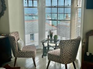 圣艾夫斯Seaforth St Ives的客房设有桌子、两把椅子和窗户。