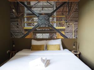 蒂尔堡Hostel Roots的卧室配有一张带黄色枕头的大型白色床。