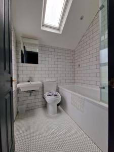 惠特利湾Lovely 3 bedroom Whitley Bay Townhouse.的浴室配有卫生间、盥洗盆和浴缸。