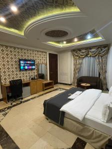 阿布贾Hotel 5092的一间卧室配有一张床、一张书桌和一台电视。