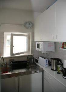 柏林公园绿洲公寓 的厨房配有水槽和墙上的时钟