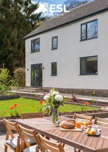 MinsterleyLarge Country Farmhouse with Hot Tub and Shropshire Hills View的花瓶和房子的桌子