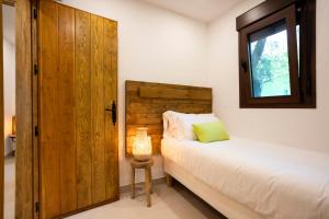塔里法Dunas Luxury Beach Resort Tarifa的一间卧室配有一张床和一扇木门