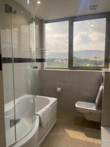 阿布贾Hotel 5092的带浴缸、卫生间和窗户的浴室