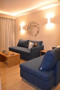 帕莱欧卡斯提撒奥德修斯酒店的客厅配有蓝色的沙发和桌子