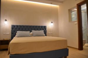 帕莱欧卡斯提撒奥德修斯酒店的一间卧室配有一张大床和蓝色床头板