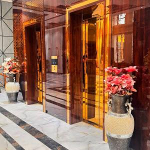 杜尚别KANGURT Grand Hotel的两瓶花花在建筑物前