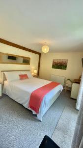 沃辛Windmill Cottage的卧室配有一张大白色床和红色毯子