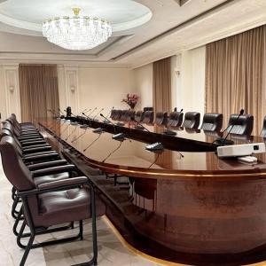 杜尚别KANGURT Grand Hotel的大型会议室,配有长桌子和椅子