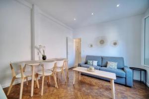 戛纳LOENA CANNES CENTRE - Appartement rénové 2 pièces - 4 personnes - proche croisette palais festival plage - internet gratuit - climatisation - non fumeur的客厅配有桌子和蓝色沙发