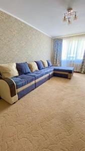 塔拉兹2х комнатная квартира на Толе би的客厅里一张大蓝色沙发