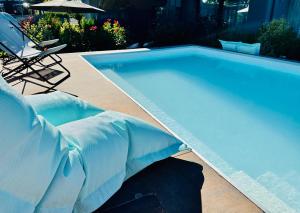 西尔米奥奈Boutique Hotel Sirmione的蓝色游泳池,配有椅子和遮阳伞