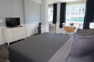 科罗拉The Inn at Corolla的一间卧室配有一张带紫色枕头的床和一台电视。