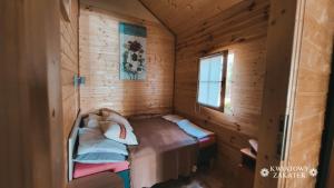 梅尔诺Mielno - Kwiatowy Zakątek #2的小木屋内的小房间,配有一张床