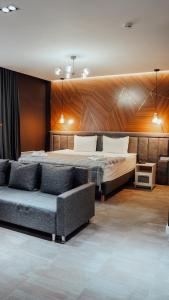 休钦斯克Timber Boutique Hotel Borovoe的一间卧室配有一张床和一张沙发