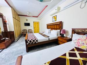 伊斯兰堡Lexus Lodge的酒店客房设有两张床和电视。