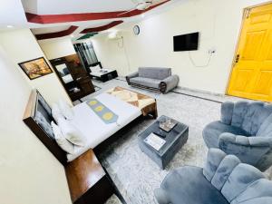 伊斯兰堡Lexus Lodge的客厅配有一张床和两把椅子