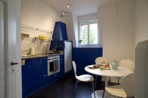 伯尔尼artroom的厨房配有蓝色橱柜和桌椅