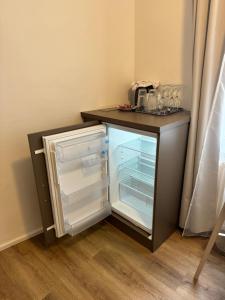 布尔诺中央公寓酒店的冰箱,门开在柜台旁