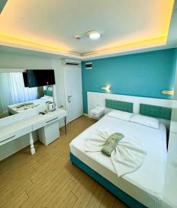 凯麦尔Amsterdam Otel & Suite Apart的一间卧室设有蓝色的墙壁、一张床和一张书桌