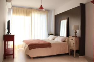 布宜诺斯艾利斯米莉诺公寓酒店的一间卧室配有一张床和一台电视