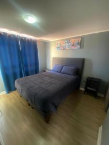 La Chimbacasa的一间卧室配有一张带蓝色床单和蓝色窗帘的床。