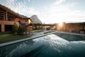 科尔福索Kolfuschgerhof Mountain Resort的一座房子,设有一座山地游泳池