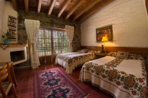 ZitácuaroHotel Rancho San Cayetano的一间卧室设有两张床和窗户。