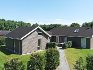 Egense10 person holiday home in Storvorde的黑色屋顶的房子
